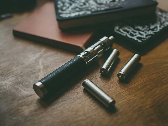 Vape Pen and Lithium Ion Batteries on a Table