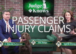 J. David Greene of Greene & Phillips Injury Lawyers and host April Douglas on the Judge Knows set with Judge the chocolate lab, discussing passenger injury claims after a car accident